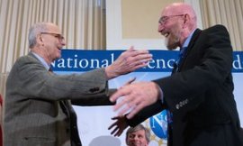 Ligio co-founder Rainer Weiss, left, and Kip Thorne, right, hug on stage during a news conference at the National Press Club in Washington.